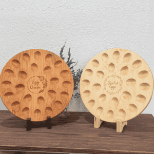 Two wooden deviled egg trays in cherry and maple wood shown side by side on table