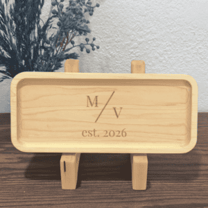 Personalized wooden ring dish displayed on stand with engraved initials and established date
