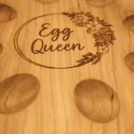 Close up of Egg Queen engraving with floral design on cherry wood tray
