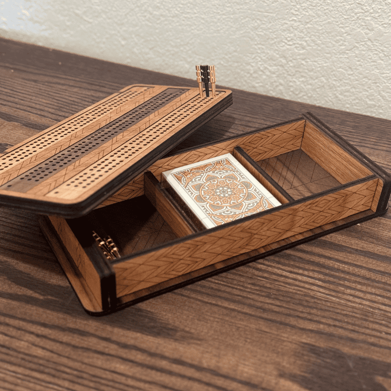 cribbage board with playing cards and pegs.